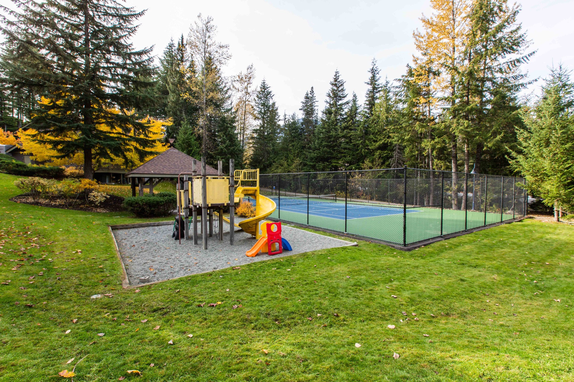 Suncrest community playground and tennis court in a forested Whistler setting